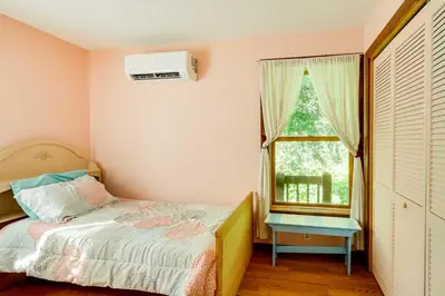 a small bedroom with a bed and a window at Spacious Woodbury Home with Pool and Hot Tub! in Woodbury