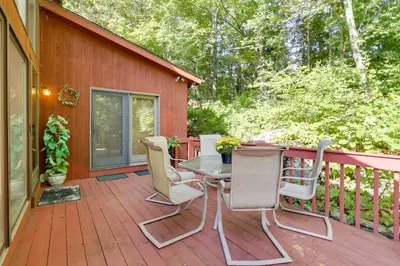 a deck with a table and chairs on a house at Spacious Woodbury Home with Pool and Hot Tub! in Woodbury