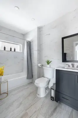 a white bathroom with a toilet and a sink at Sleek 1 Bedroom Apartment Plus Balcony 30 Mins to NYC in New Rochelle
