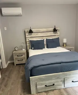 a bedroom with a bed with a wooden headboard at Sleek 1 Bedroom Apartment Plus Balcony 30 Mins to NYC in New Rochelle