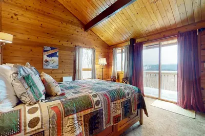 a bedroom with a bed in a room with wooden walls at Mountain View Chalet in West Dover
