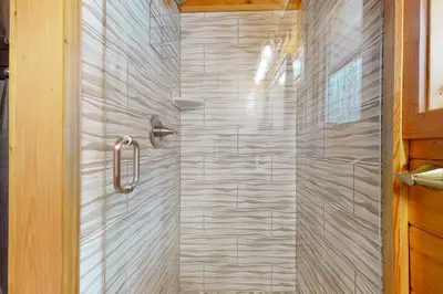 a shower with a glass door in a bathroom at Mountain View Chalet in West Dover