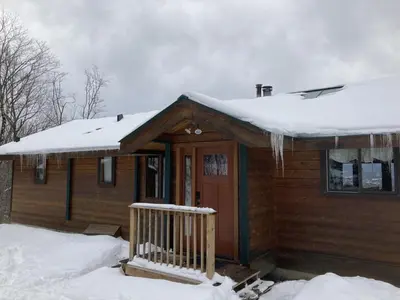 a log cabin with snow on the roof at Mountain View Chalet in West Dover