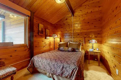 a bedroom with a bed in a log cabin at Mountain View Chalet in West Dover