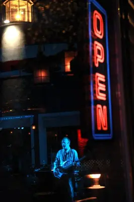a man sitting in front of a neon sign at Lake Front Hotel in Cooperstown