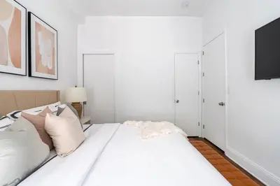 a white bedroom with a bed with white pillows at 91-1D 3BR 2baths Duplex with a Private Back yard - GYM in New York