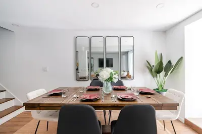a dining room with a table with chairs and a mirror at 91-1D 3BR 2baths Duplex with a Private Back yard - GYM in New York