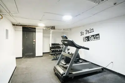 a gym with a treadmill and a sign on the wall at 91-1D 3BR 2baths Duplex with a Private Back yard - GYM in New York