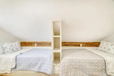 a bedroom with two beds and a book shelf at Hot Tub and Lake Access at Poconos Getaway! in Lake Ariel