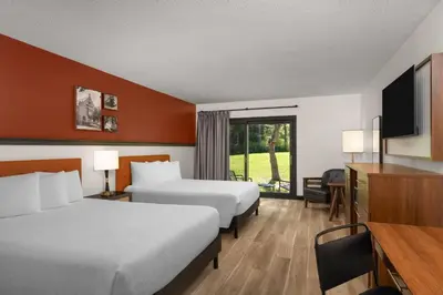 a hotel room with two beds and a flat screen tv at Hotel Vervana, Trademark Collection by Wyndham in Bennington