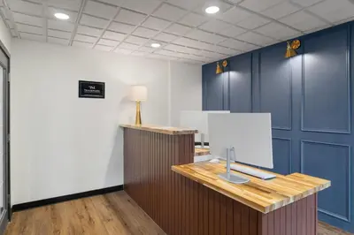 a room with blue cabinets and a desk with a lamp at Hotel Vervana, Trademark Collection by Wyndham in Bennington