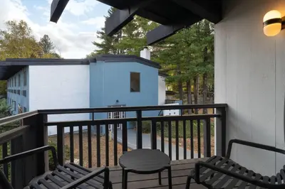 a balcony with a bench and a blue building at Hotel Vervana, Trademark Collection by Wyndham in Bennington