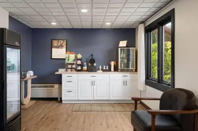 a room with white cabinets and a blue wall at Hotel Vervana, Trademark Collection by Wyndham in Bennington
