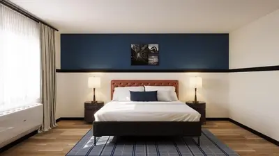 a bedroom with a large bed with a blue wall at Hotel Vervana, Trademark Collection by Wyndham in Bennington