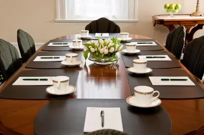a long table with cups and a vase of flowers at Saratoga Arms Hotel in Saratoga Springs