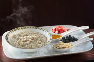 a tray with two bowls of oatmeal and bowls of fruit at Saratoga Arms Hotel in Saratoga Springs