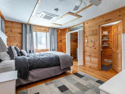 a bedroom with a bed in a room with wooden walls at Cozy 2-bedroom Cottage with Access to Bantam Lake in Morris