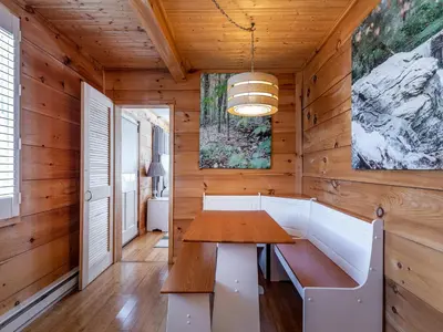 a dining room with a table and a bench at Cozy 2-bedroom Cottage with Access to Bantam Lake in Morris