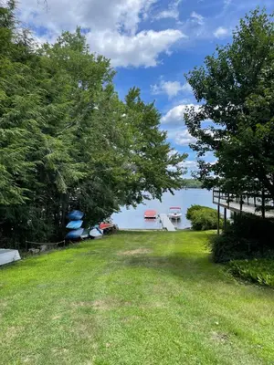 a yard with trees and a view of the water at Cozy 2-bedroom Cottage with Access to Bantam Lake in Morris