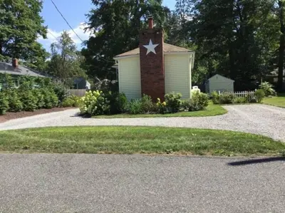 a brick house with a star on the side of it at Cozy 2-bedroom Cottage with Access to Bantam Lake in Morris