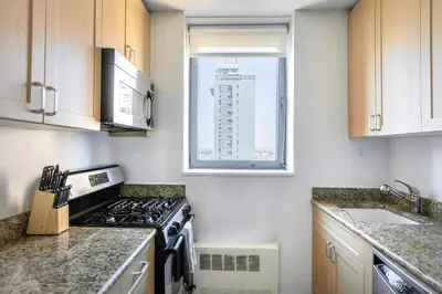 a kitchen with a stove top oven next to a window at Sq 1BR w Great views Indoor pool NYC-29 in New York
