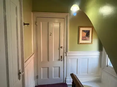a hallway with a white door in a green wall at 2Br Private Victorian Apartment in City location on half acre Sleeps 5 in Poughkeepsie