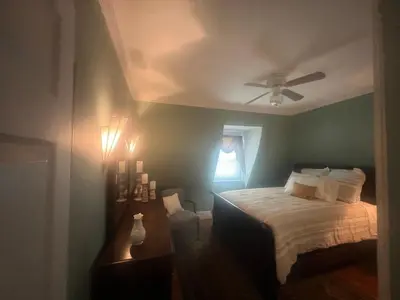 a bedroom with a bed and a ceiling fan at 2Br Private Victorian Apartment in City location on half acre Sleeps 5 in Poughkeepsie