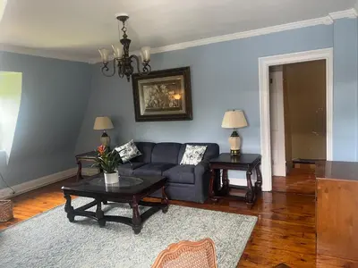 a living room with a couch and a table at 2Br Private Victorian Apartment in City location on half acre Sleeps 5 in Poughkeepsie