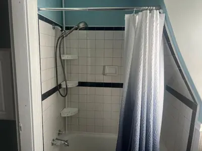a bathroom with a shower with a shower curtain at 2Br Private Victorian Apartment in City location on half acre Sleeps 5 in Poughkeepsie