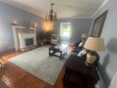 a living room with a couch and a fireplace at 2Br Private Victorian Apartment in City location on half acre Sleeps 5 in Poughkeepsie