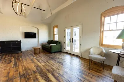 a living room with a couch and a table at voco James Newbury Hudson Valley by IHG in Coxsackie