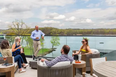 a group of people sitting in chairs on a patio at voco James Newbury Hudson Valley by IHG in Coxsackie