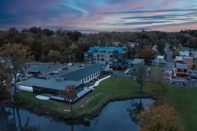 an aerial view of a building next to a body of water at voco James Newbury Hudson Valley by IHG in Coxsackie