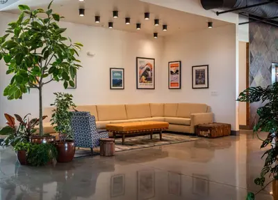 a living room with a couch and potted plants at voco James Newbury Hudson Valley by IHG in Coxsackie