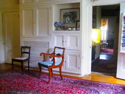 a living room with two chairs and a rug at The White House Inn in Cooperstown