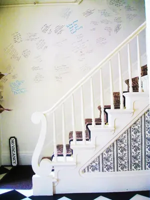 a staircase with writing on the wall in a room at The White House Inn in Cooperstown