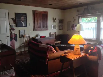 a living room with a couch and a lamp on a table at The White House Inn in Cooperstown