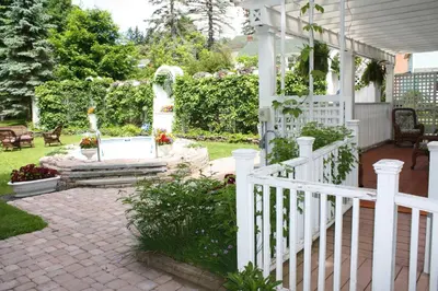 a porch with a white fence and a bench at The White House Inn in Cooperstown