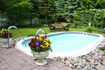 a swimming pool with flowers in vases in a yard at The White House Inn in Cooperstown