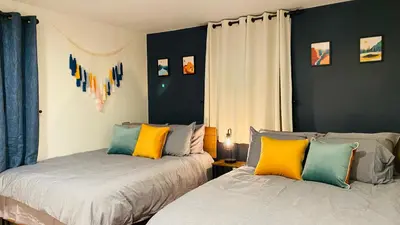 two beds in a room with blue and yellow pillows at Family retreat, Closest Rental House to POOL & BEACH, Hot tub, Game Room in Tobyhanna