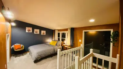 a bedroom with a bed and a staircase with a window at Family retreat, Closest Rental House to POOL & BEACH, Hot tub, Game Room in Tobyhanna