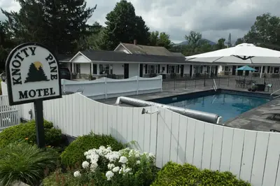 a motel sign in front of a swimming pool at Knotty Pine Motel in Bennington