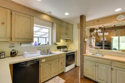 a kitchen with wooden cabinets and a black dishwasher at Serene Salisbury Rental Home on 26 Acres with Deck! in Salisbury