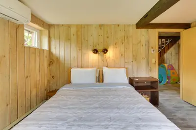 a bedroom with a large bed in a wooden wall at Serene Salisbury Rental Home on 26 Acres with Deck! in Salisbury