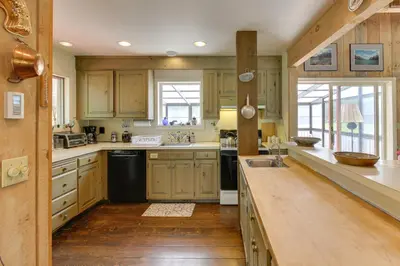 a kitchen with wooden cabinets and a wooden floor at Serene Salisbury Rental Home on 26 Acres with Deck! in Salisbury