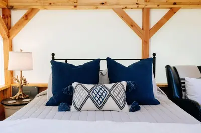 a bedroom with a bed with blue and white pillows at Battenkill Glamping Resort in Cambridge