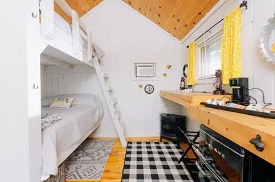 a small bedroom with a bunk bed and a ladder at Battenkill Glamping Resort in Cambridge