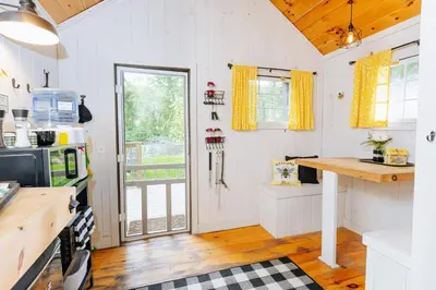a kitchen with white walls and a wooden floor at Battenkill Glamping Resort in Cambridge