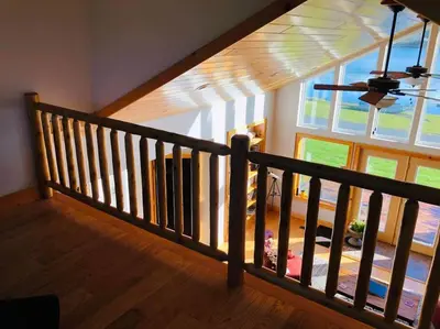 a staircase in a house with a large window at Silver Lake Cabin w/ Own Lake! (near Cooperstown) in New Berlin