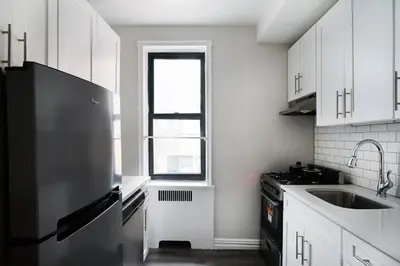 a kitchen with a black refrigerator and a window at 105 -5G Brand New Studio prime location Elevator in New York